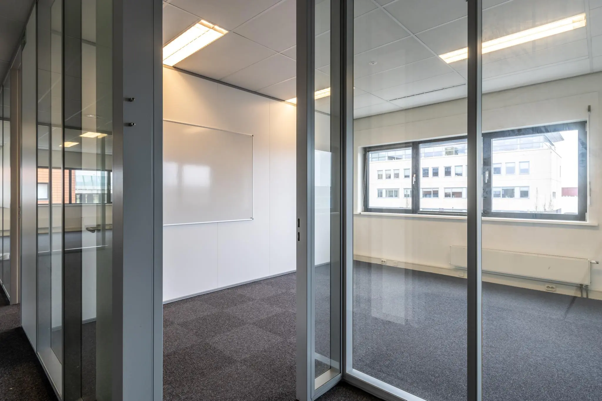 Modern, licht kantoorruimte met glazen wanden aan de Lage Biezenweg.